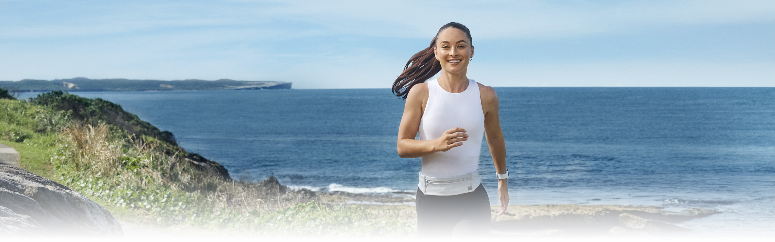 A woman is running outdoors wearing Galaxy Watch8.